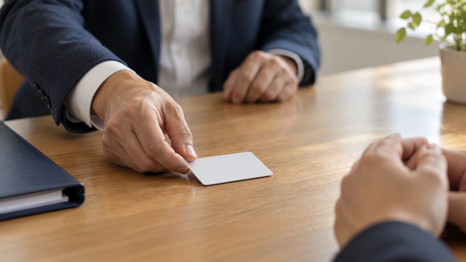 テーブル越しに、身分証のようなカードを1枚差し出している日本人の手元