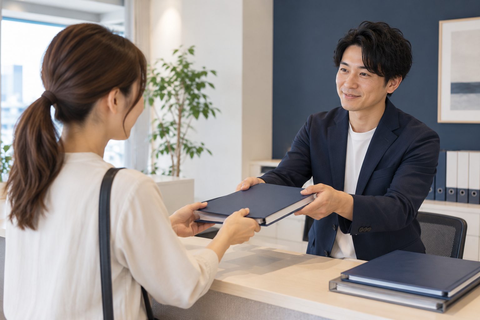 管理会社の窓口でマンションの資料を受け取る様子