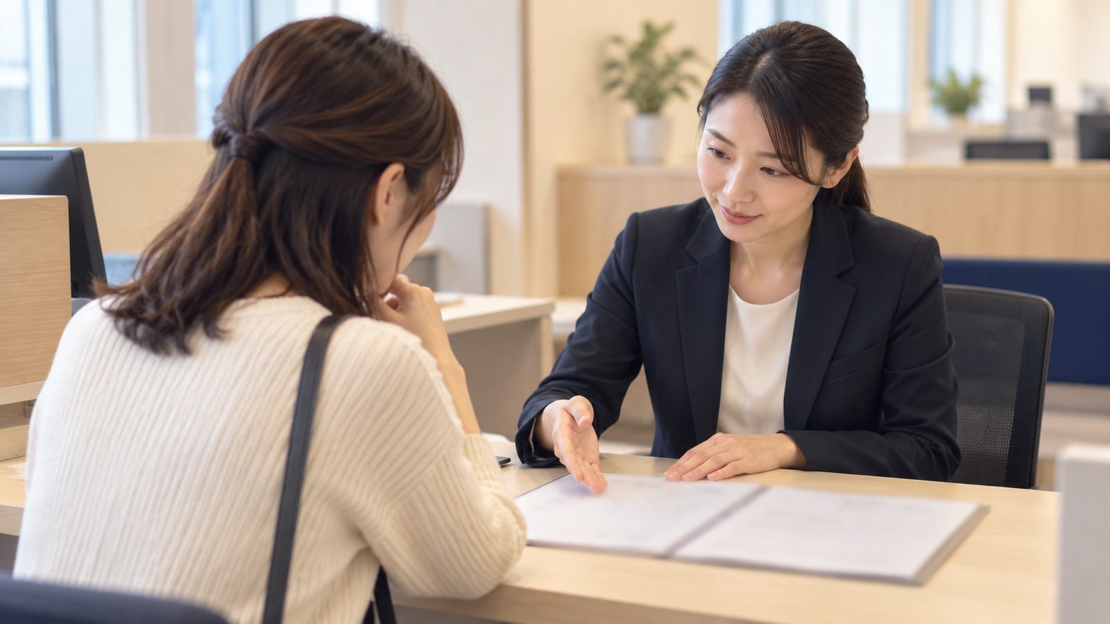 金融機関の相談カウンターで説明を受ける女性